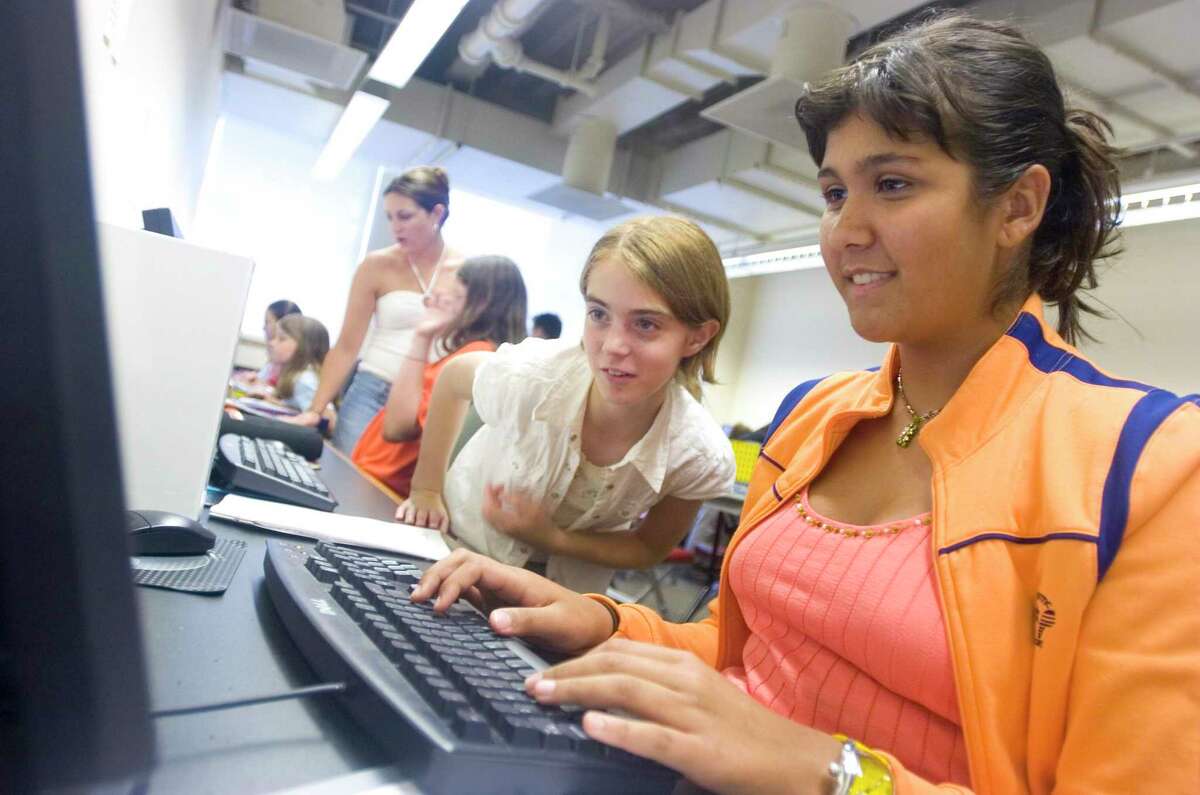 Anna Azevedo, 12, of Norwalk, right, shows Nikki Barnhart, 12, of Newtown, the website she is working on at the National Computer Camps one-week computer camp for area girls. The camp is directed by professor Michael Zabinski.
