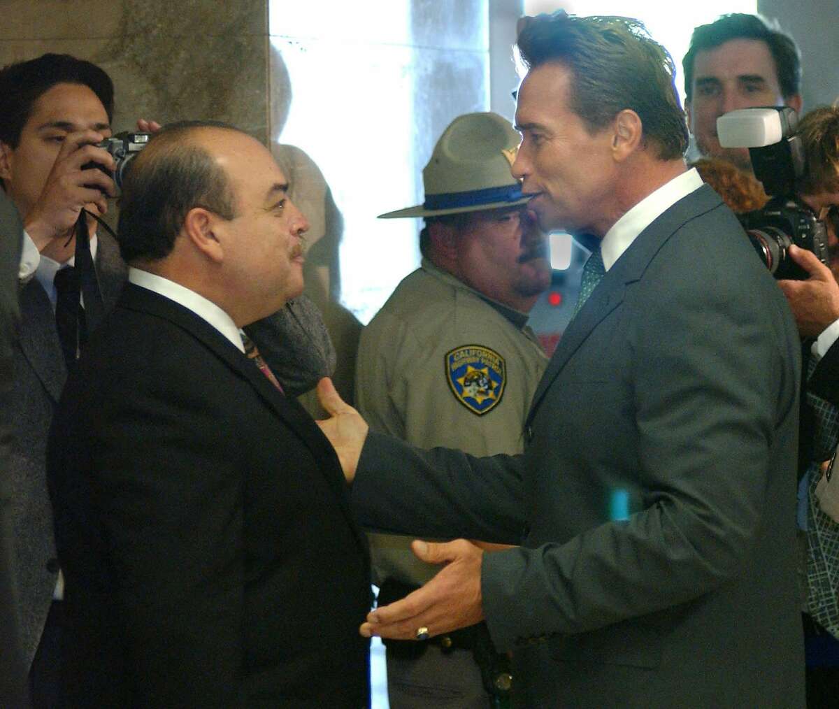 2003年10月，加州选民罢免格雷·戴维斯州长后，副州长克鲁兹·布斯塔曼特(左)与当选州长阿诺德·施瓦辛格交谈。布斯塔曼特作为替代候选人竞选失败。