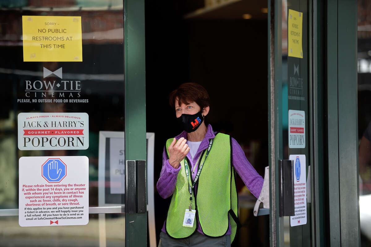 Volunteer Patricia Czako helps local residents line up at the Ultimate Regent 8 movie theater where the Norwalk Health Department held a mass COVID vaccination clinic in the lobby of the theater Wednesday, April 7, 2021, in Norwalk, Conn. The Bow Tie Cinemas theater owner partnered with the healtth department to host the public COVID vaccination clinic.