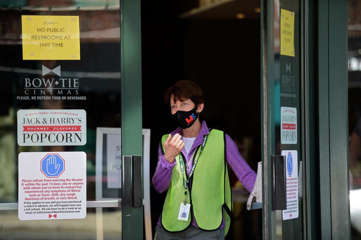 Volunteer Patricia Czako helps local residents line up at the Ultimate Regent 8 movie theater where the Norwalk Health Department held a mass COVID vaccination clinic in the lobby of the theater Wednesday, April 7, 2021, in Norwalk, Conn. The Bow Tie Cinemas theater owner partnered with the healtth department to host the public COVID vaccination clinic.