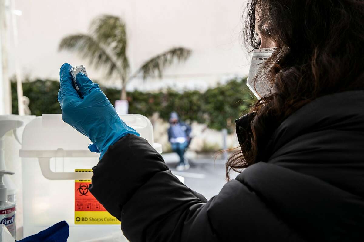 COVID: Are you maybe asymptomatic if you've never tested positive? Nurse Joy Ceniza prepares a dosage of Moderna COVID-19 vaccine at a neighborhood vaccination site in the Excelsior district of San Francisco, California Wednesday April 7, 2021.