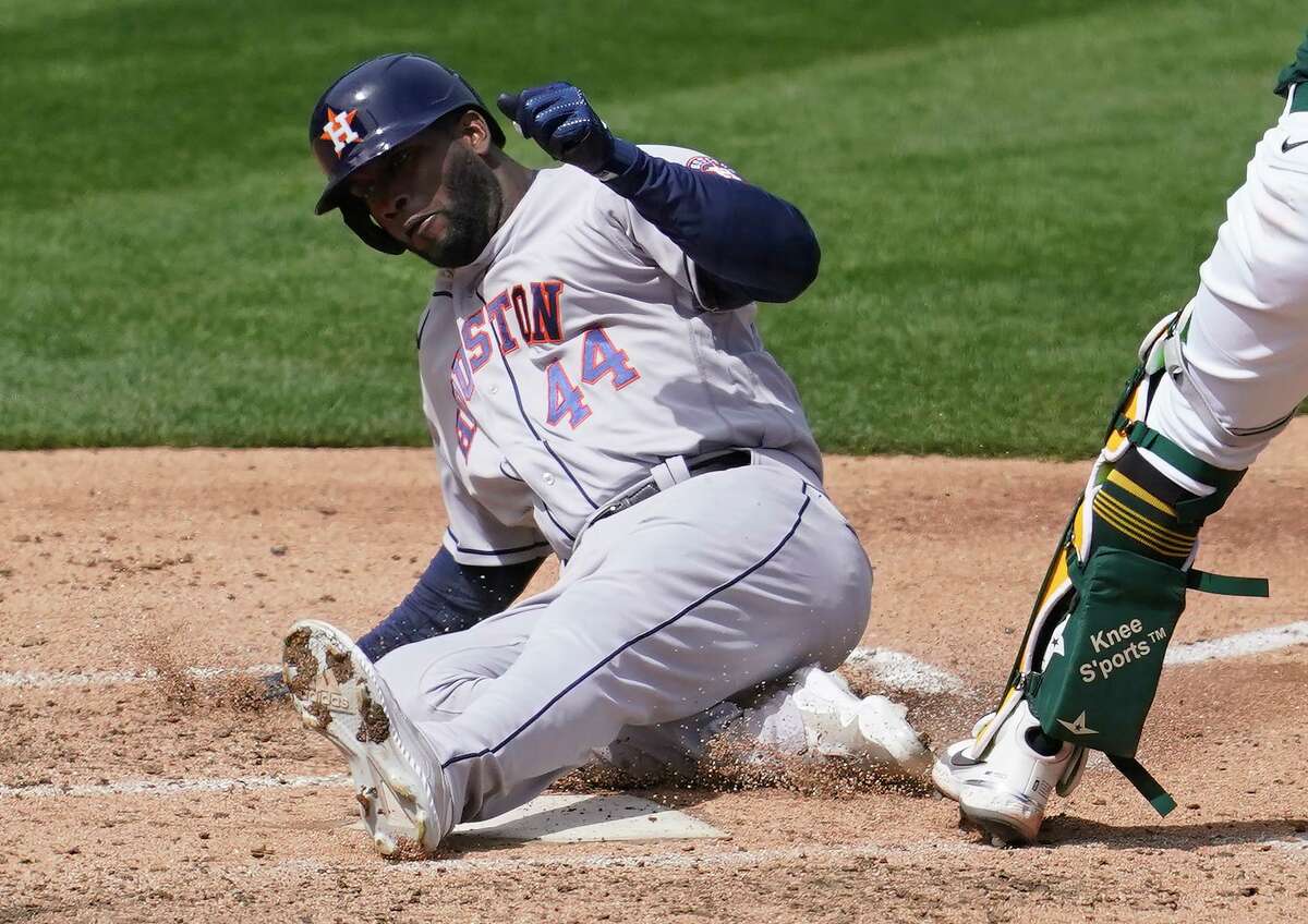 Astros designated hitter Yordan Alvarez slides across the plate after running from first to home during Sunday’s 9-2 victory at Oakland.