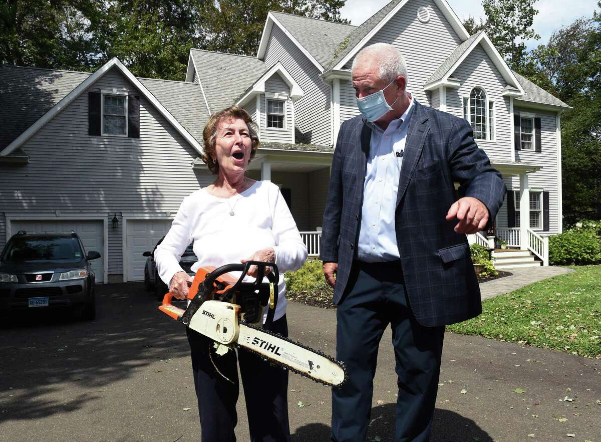Betty Perrone speaks with Eversource Executive Vice President Joseph Nolan while carrying her chainsaw in front of her home on Damascus Road in Branford on August 28, 2020. Nolan will become CEO on May 5.