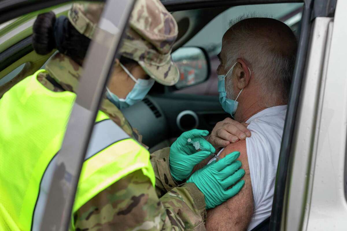 Dean Skevas, of Wethersfield, gets a vaccination shot from Stefanie Charpentier of the Connecticut National Guard at mass vaccination center on the former Pratt & Whitney Runway at Rentschler Field in East Hartford, Conn. March 1, 2021.