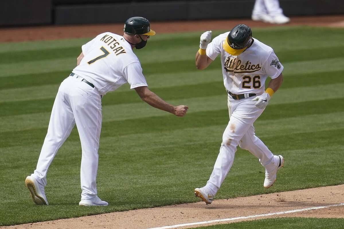 Matt Chapman is congratulated by third base coach Mark Kotsay after hitting a solo home run in the seventh inning.