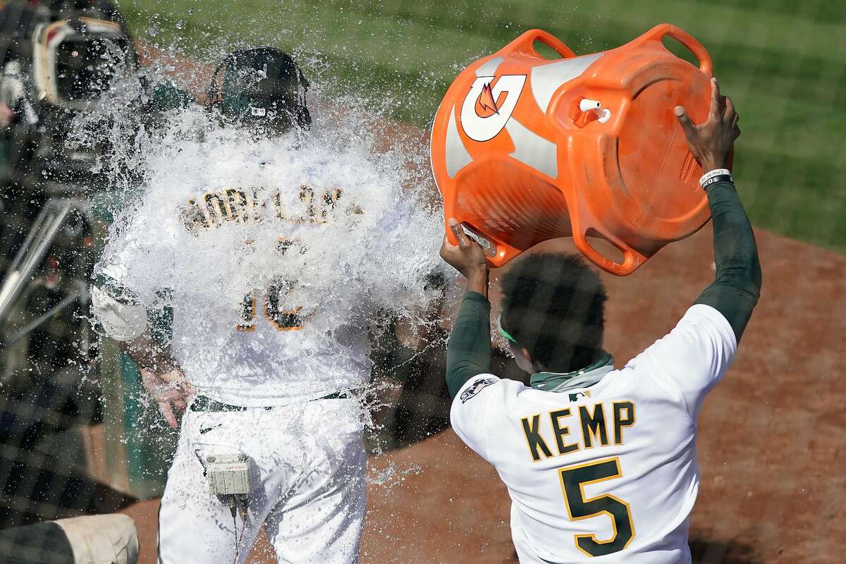 Tony Kemp dumps water onto the back of Mitch Moreland, who had just driven in the winning run in the 10th inning.
