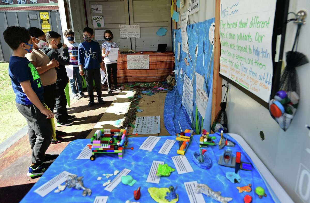 A group of Tracey Elementary School third and fifth-grade students including Mayar Elwerfally, 3rd, Zayn Mir, 3rd, and Angel Contreras, 5th, at right, who created a diorama of Calf Pasture Beach's ecosystem in a shipping container outside the school held tours for other students Wednesday, April 7, 2021, in Norwalk, Conn. The project was one of the school's Service Learning Projects which pairs academic learning with the school's core values.