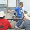 Riley Bruce, 7, hangs on tight to a mechanical bull Sunday during the festivities for the Cowboy Church of Orange County's third anniversary celebration. Guiseppe Barranco/The Enterprise