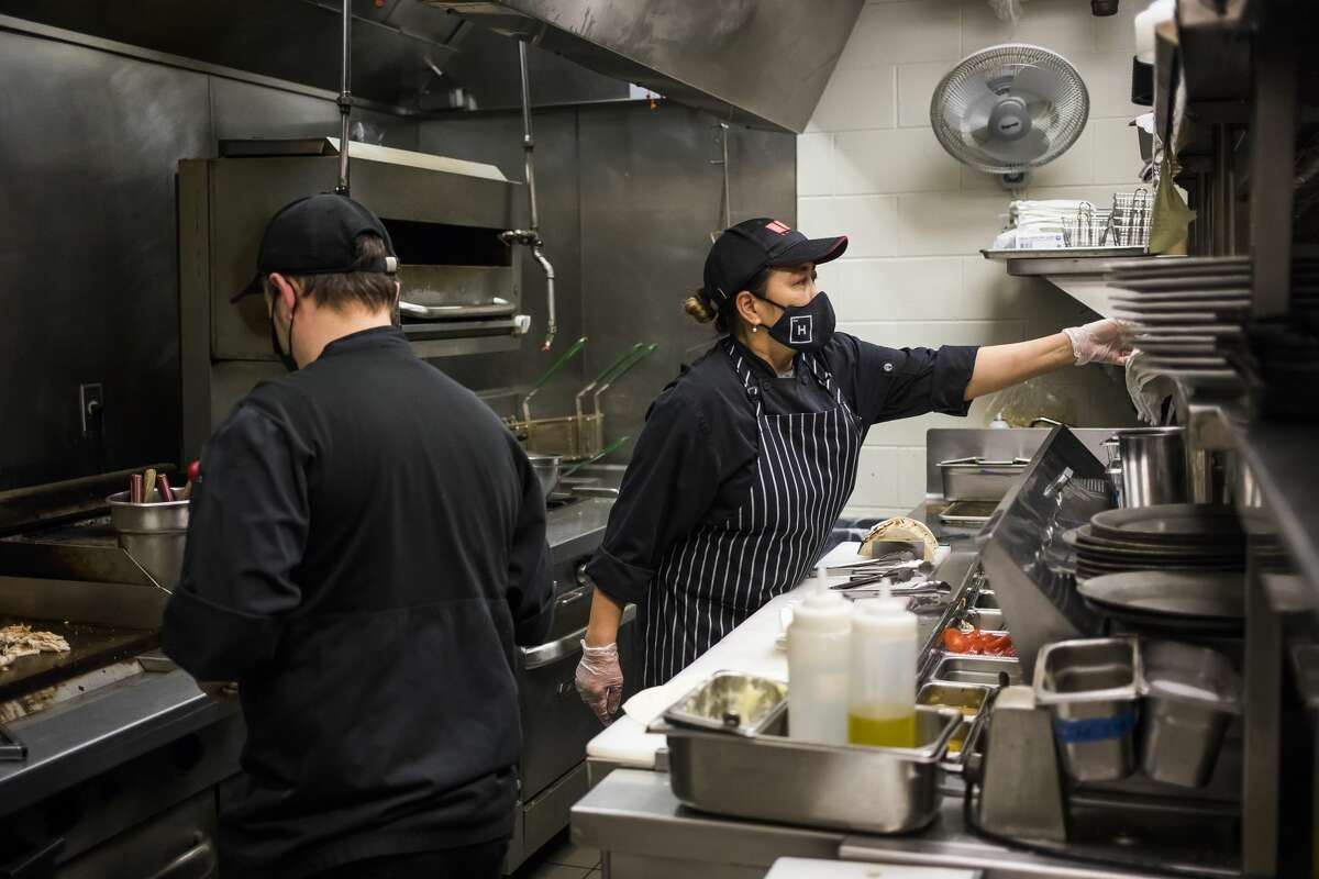Line cooks Marilyn Higbee, right, and Josh Fisch, left, prepare dishes inside the kitchen of Cafe Zinc Thursday, April 8, 2021 at The H Hotel in downtown Midland. (Katy Kildee/kkildee@mdn.net)