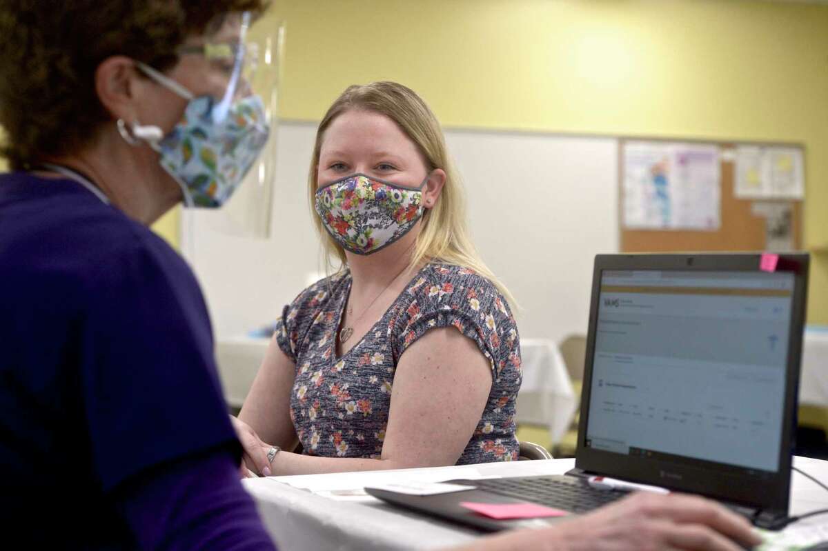 Jennifer Barabas, of Brookfield, has her information taken down by pharmacist Kathy Haddy before she receives her first dose of COVID-19 vaccine at the new location of the Brookfield clinic. The clinic is set up in the old St Joseph Catholic Academy. Wednesday, April 8, 2021, in Brookfield, Conn.