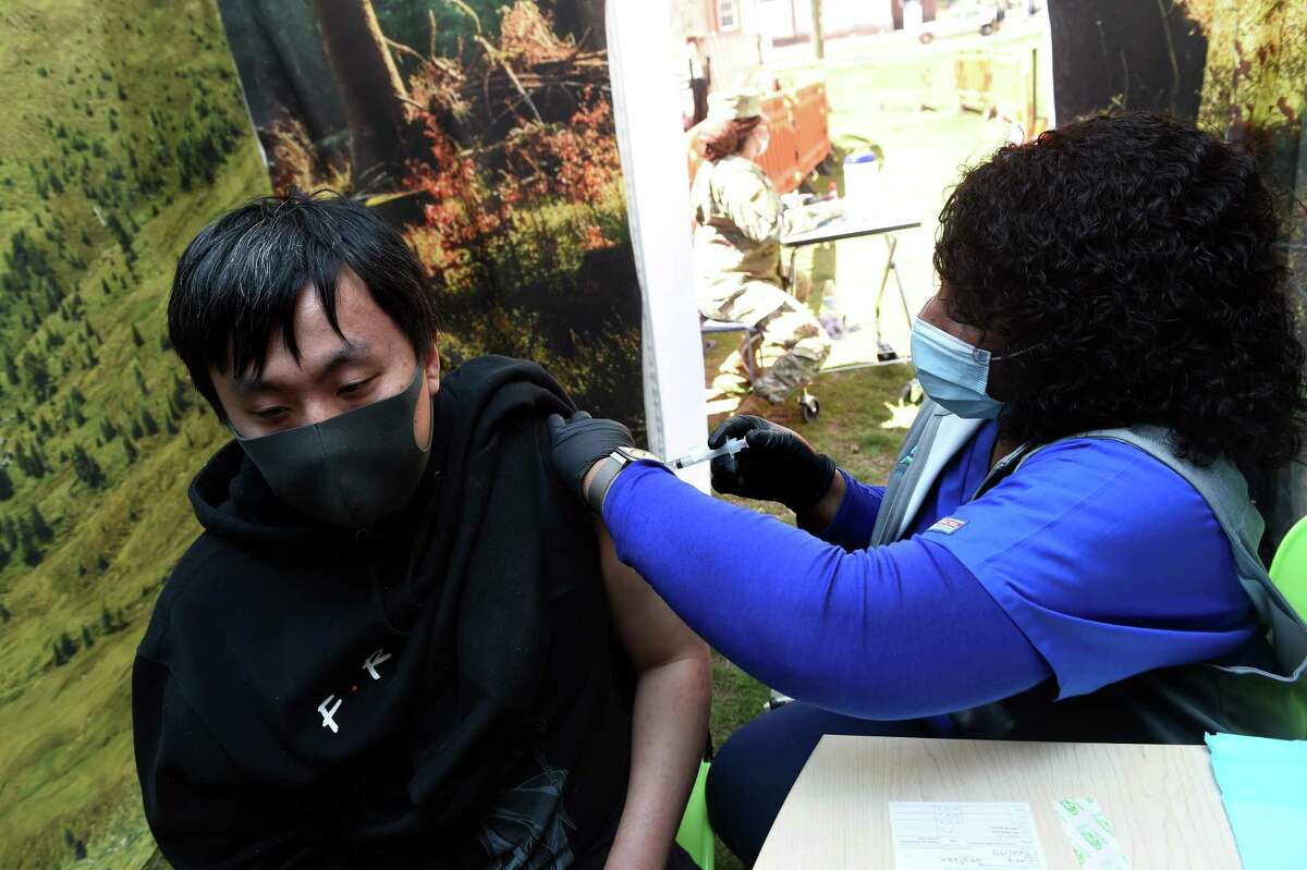 Griffin Hospital RN Cynthia Dore (right) gives Jonathan Chang of Orange a Johnson & Johnson COVID-19 vaccination at a COVID-19 FEMA Mobile Vaccination Unit set up on the New Haven Green on April 8, 2021.