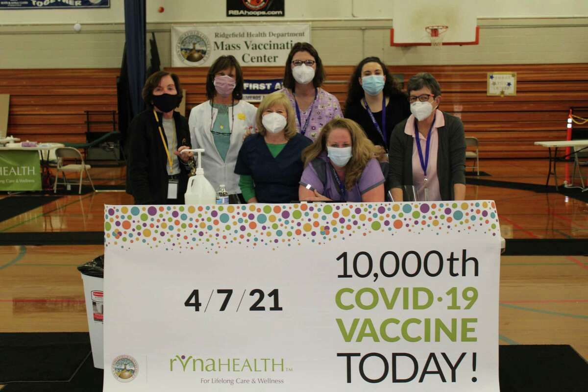 RVNAhealth personnel Meg Spera, Deb Soyak, Ellen Lennon, Christina Tremblay, Leslie Purwin, Lizzie Richards and Jayne Flynn stand by the commemorative banner after administering 10,000 COVID-19 vaccine shots at Ridgefield’s collaborative clinic.