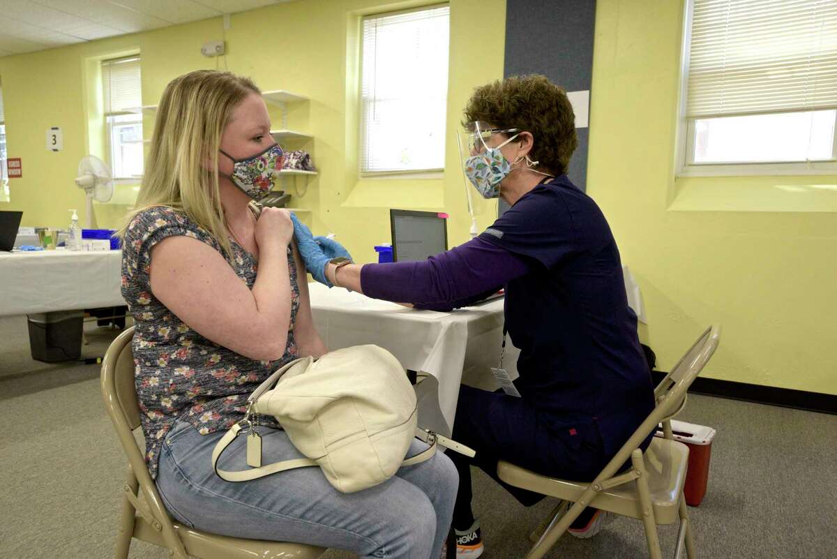 Jennifer Barabas, of Brookfield, receives her first dose of COVID-19 vaccine at the new location of the Brookfield clinic from pharmacist Kathy Haddy. The clinic is set up in the old St Joseph Catholic Academy. Wednesday, April 8, 2021, in Brookfield, Conn.