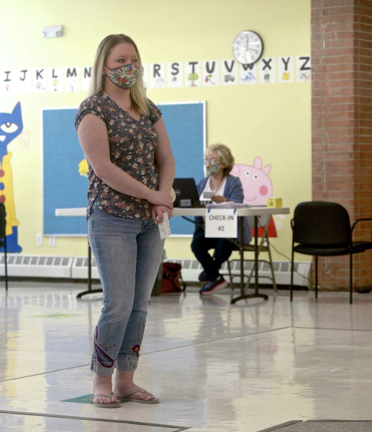 Jennifer Barabas, of Brookfield, waits to received her first dose of COVID-19 vaccine at the new location of the Brookfield clinic, set up at the old St Joseph Catholic Academy. Wednesday, April 8, 2021, in Brookfield, Conn.