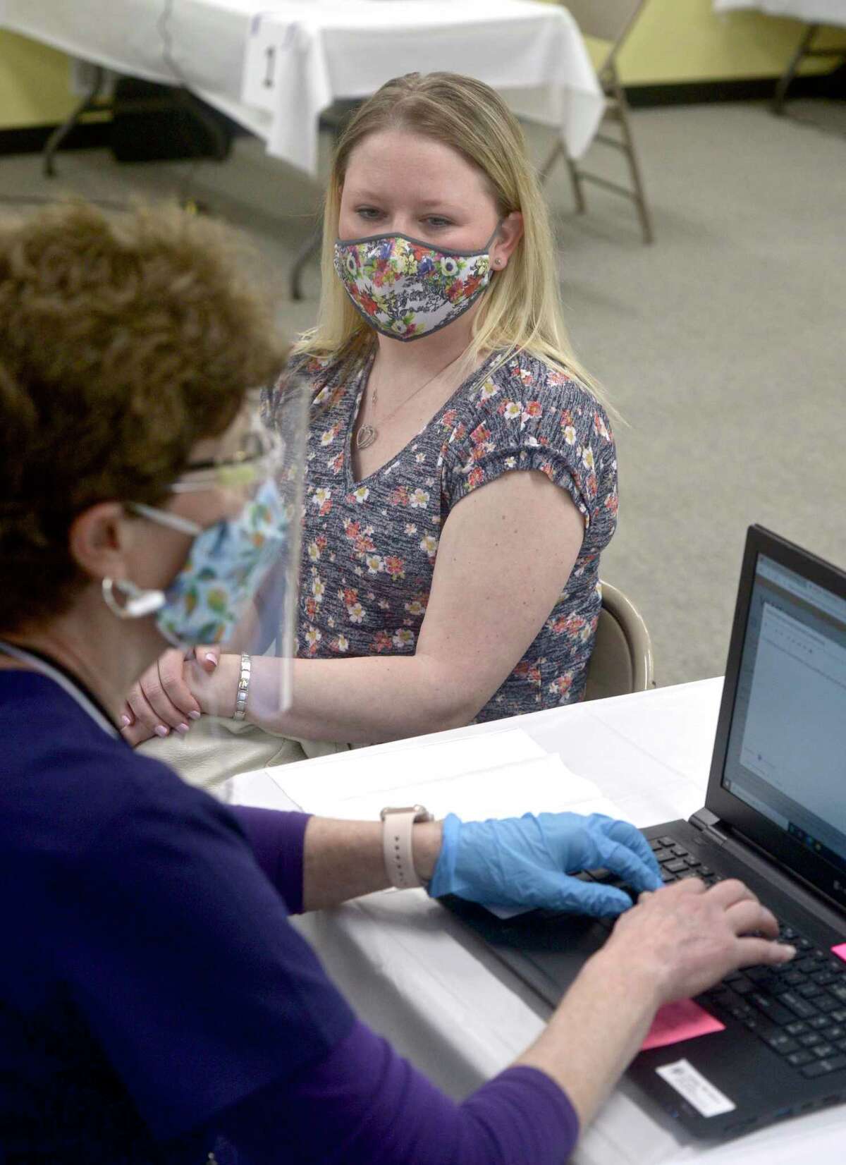 Jennifer Barabas, of Brookfield, has her information taken down by pharmacist Kathy Haddy before she receives her first dose of COVID-19 vaccine at the new location of the Brookfield clinic. The clinic is set up in the old St Joseph Catholic Academy. Wednesday, April 8, 2021, in Brookfield, Conn.