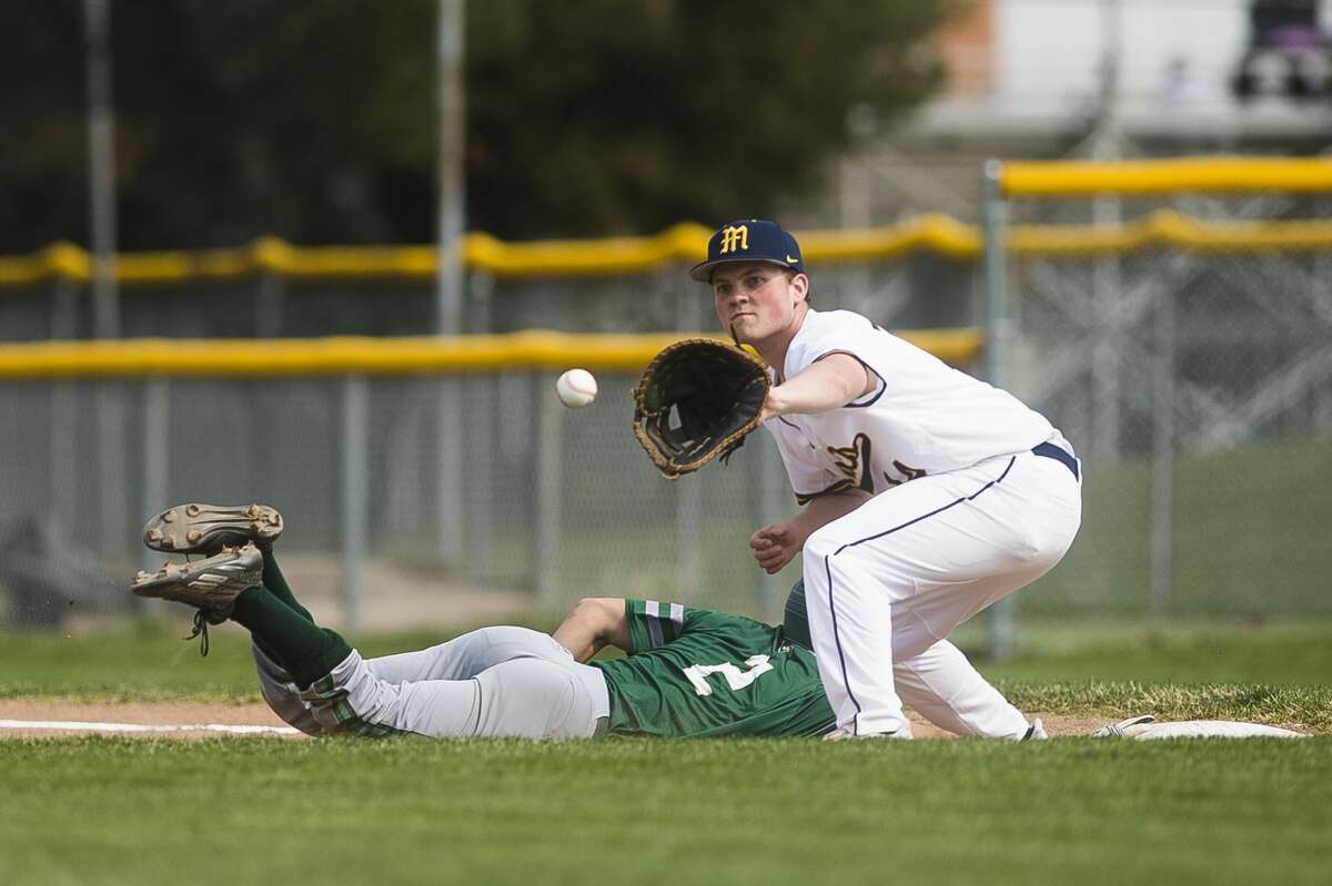 Midland's Jackson Poole catches the ball in an attempt to tag out a runner during the Chemics' game against Traverse City West Thursday, April 8, 2021 at Midland High School. (Katy Kildee/kkildee@mdn.net)