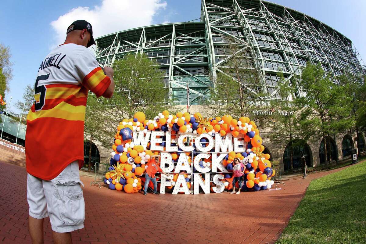Astro fans pose for photos outside of Minute Maid Park as they make their way tto watch Houston Astros home opener against the Oakland A's in Houston on Thursday, April 8, 2021.
