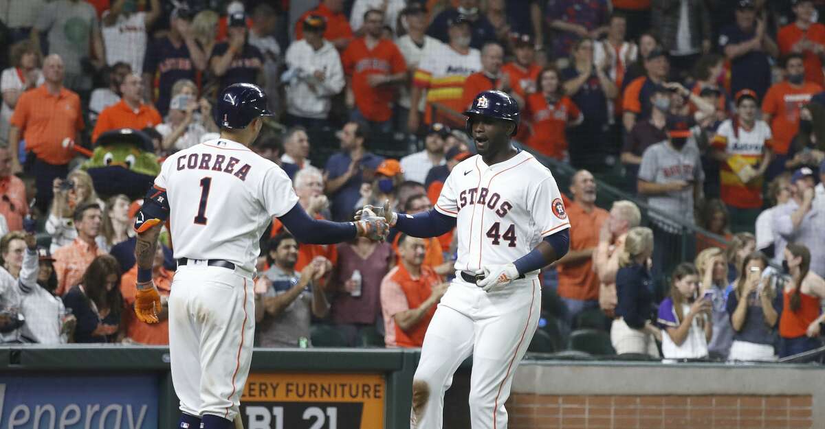 Houston Astros Yordan Alvarez (44) reacts with Carlos Correa (1) after his home run during the sixth inning of the Astros home opener MLB baseball game at Minute Maid Park, in Houston, Thursday, April 8, 2021.
