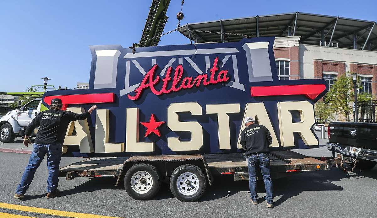 Workers load an All-Star Game sign onto a trailer after it was removed from Truist Park near Atlanta on Tuesday. Major League Baseball plans to relocate the game to Coors Field in Denver over objections to sweeping changes to Georgia’s voting laws.
