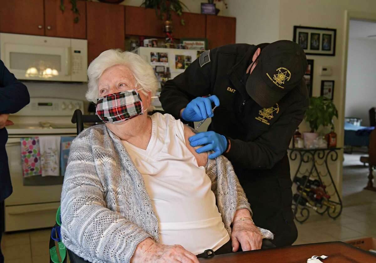 EMT and Paramedic James Mudge administers a COVID-19 vaccine in the arm of Mary Nardiello in her home on Friday, April 2, 2021 in Albany, N.Y. (Lori Van Buren/Times Union)