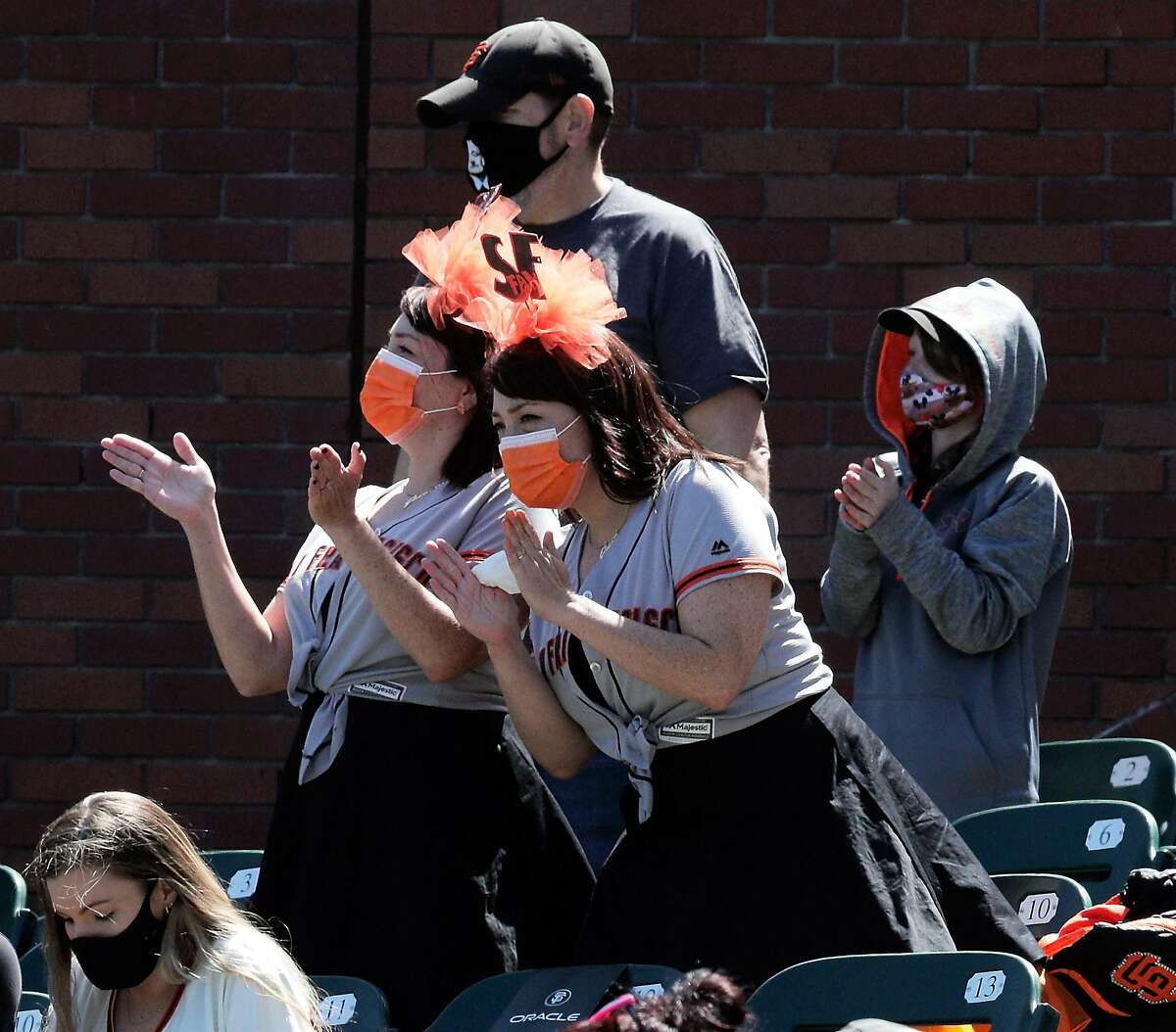 Fans cheer during introductions before the Giants played the Rockies at Oracle Park. Fans did all the things that their cardboard selves couldn’t — holler, take selfies and buy caps with holograms on them.