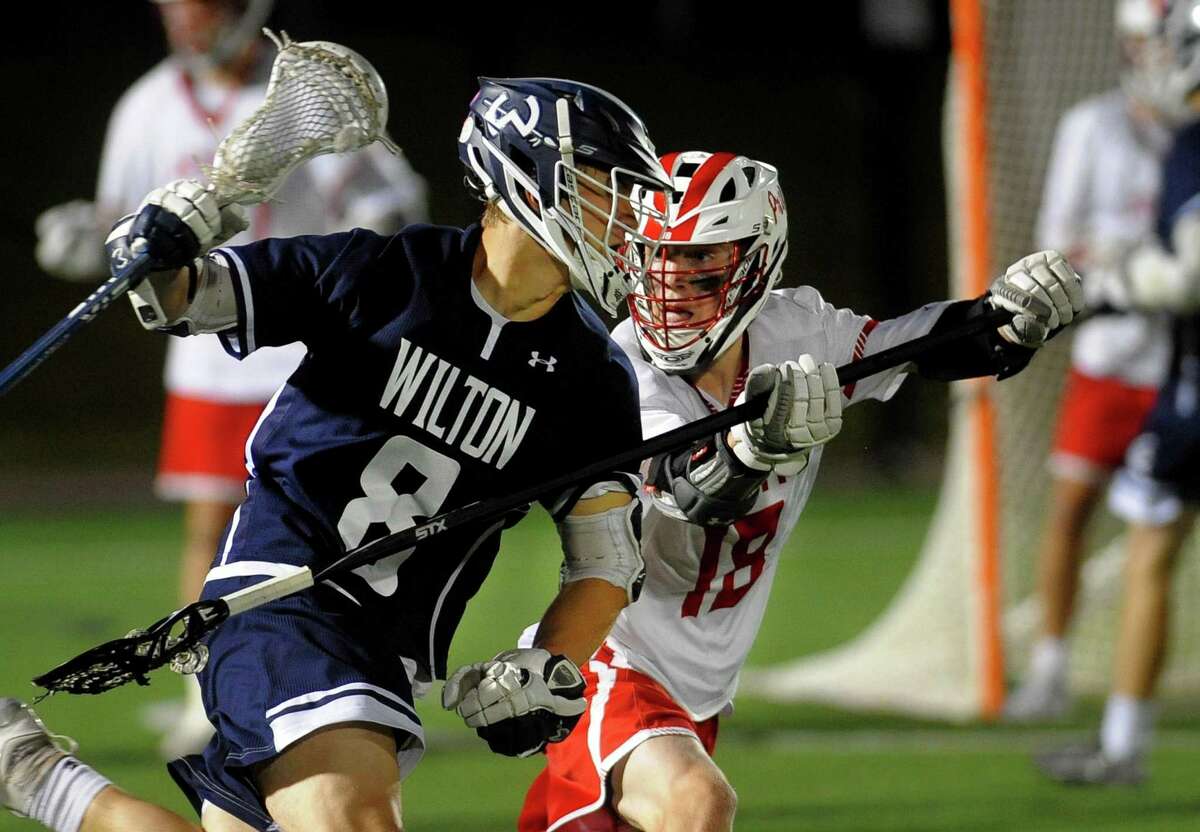 Wilton's Andrew Luciano (8) moves the ball as Fairfield Prep's Mason Whitney defends during Class L boys lacrosse semi-final action in Fairfield, Conn., on Wednesday June 5, 2019.