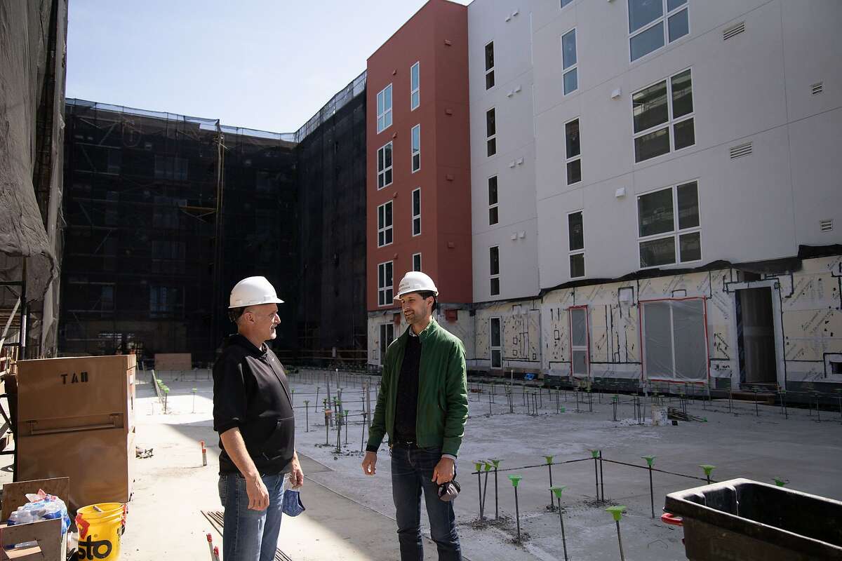 Andrew Meagher, vice president of design and engineering at Factory OS, talks with Jamie Hiteshew, director of development at Holliday, at a modular apartment building under construction near El Cerrito del Norte BART Station.