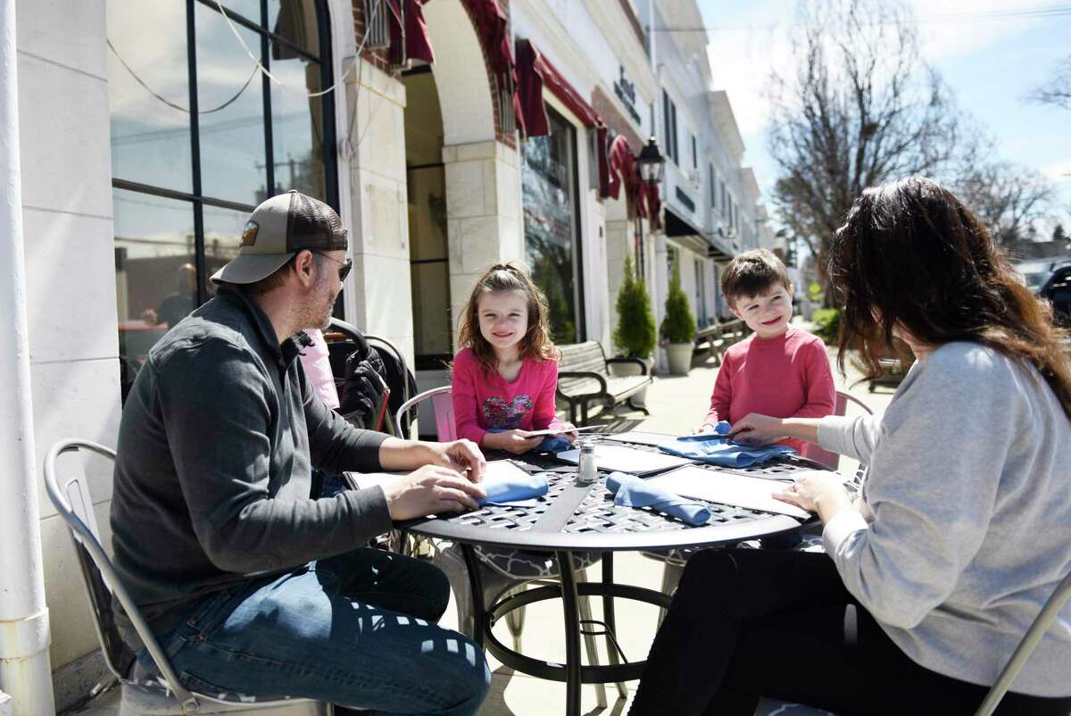 Old Greenwich residents Travis and Lauren Law dine outdoors with their children, Tatum, 4 months, Pierce, 3, and Walker, 6, at the Beach House Cafe in Old Greenwich, Conn. Wednesday, April 7, 2021.