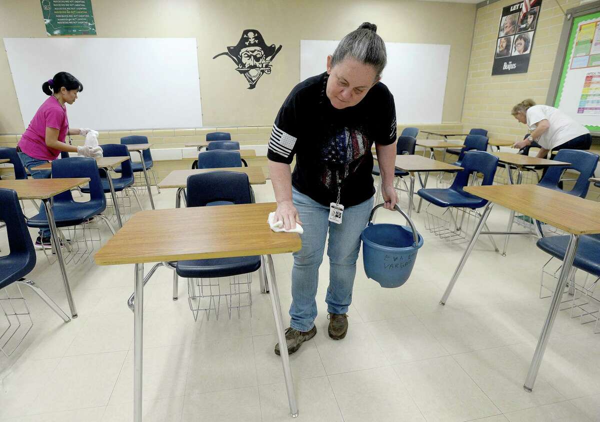 Tammy Hester, (center) head custodian for Vidor ISD, joins Marye Jane Cuntapay (left) and Tanya Crum in a classroom as they continue deep cleaning at Vidor High School Monday. Custodial staff, several of whom have volunteered their time off over spring break to complete cleaning projects at campuses throughout the district, will continue cleaning to get rid of any potential viruses and in preparation for school reconvening after the break is over next week. Photo taken Monday, March 16, 2020 Kim Brent/The Enterprise