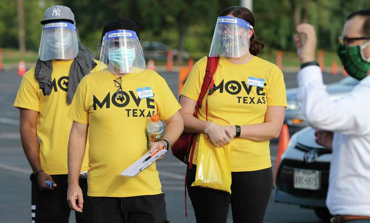 Voter registration helpers don face shields as Spurs Sports & Entertainment and non-partisan non-profit MOVE Texas team up to help people register to vote safely, simply and swiftly as possible on Tuesday, Sept. 15, 2020. Volunteers and motorists lined up early Tuesday evening on the grounds of the AT&T Center to fill out voter registration forms. New voters remained in their cars as they spoke with volunteers who helped walk them through the voter registration process. The Spurs Coyote joined and greeted people as they filled out the paperwork. As a treat for those who came out to register, the Spurs championship trophies were on display for photographs as well as a commemorative "Vote" t-shirt was available.