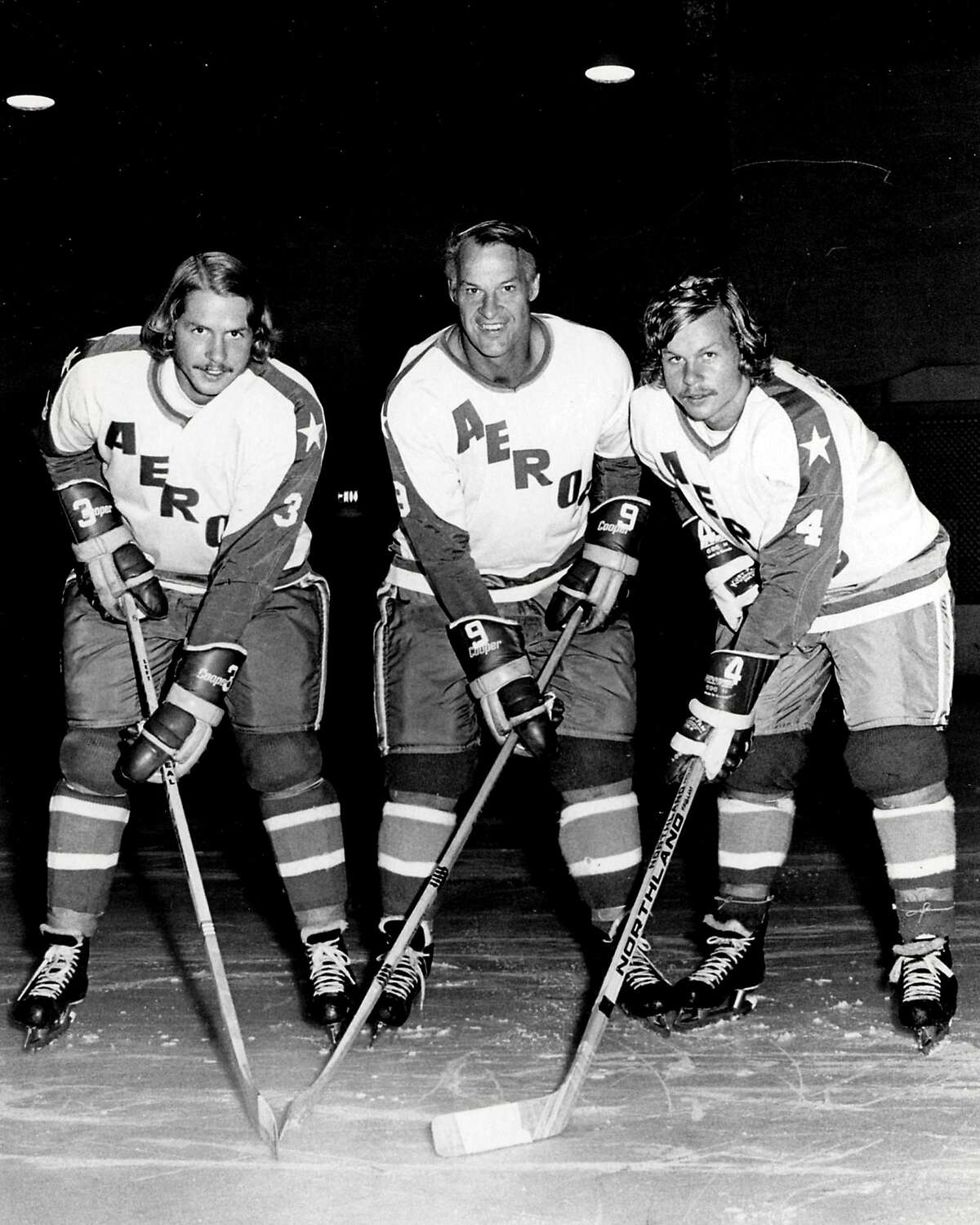 In an Aug. 3, 1973 file photo, former Detroit Red Wings great Gordie Howe, center, is flanked by sons Marty, left, and Mark as they try their new Houston Aeros uniforms in St. Clair Shores, Mich. A made-for-TV movie, "Mr. Hockey: The Gordie Howe Story," focuses on the season the Hall of Famer teamed up with his sons in Houston. The U.S. premiere of the film is Saturday, May 4, 2013. (AP Photo/The Macomb Daily, David Posavetz, FILE)