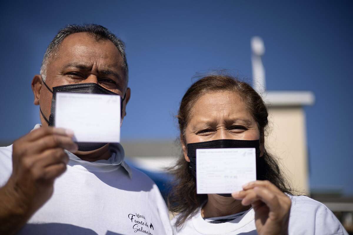 Pastor Victor Garcia and wife Milagro hold their vaccination cards after receiving the Johnson & Johnson vaccine at their Iglesia Fuente de Salvacion Church in San Pablo. They were first to receive the vaccine at the clinic.
