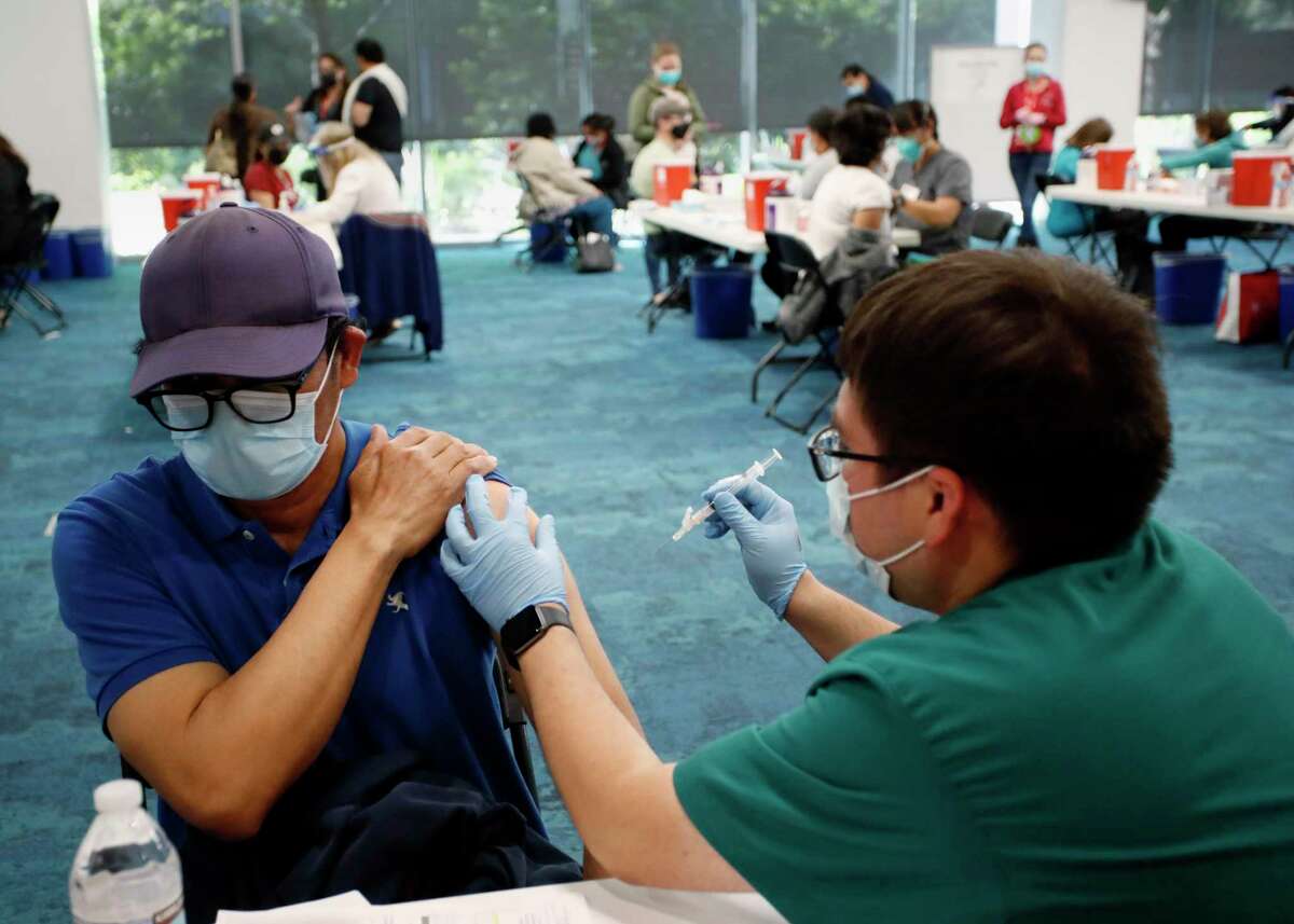 Mariano Zelaya of Redwood City receives his vaccination from Carlos Martinez at the Facebook headquarters vaccine distribution center in Menlo Park in April.