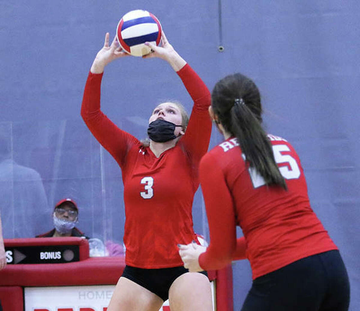 Alton’s Taylor Freer (3) sets while teammate Brooke Wolff begins her approach to the net in a match earlier this season at Alton High in Godfrey. On Saturday in Bethalto, Freer had 20 assists and Wolff had 16 kills in two matches that closed Alton’s season with an 8-11 record.