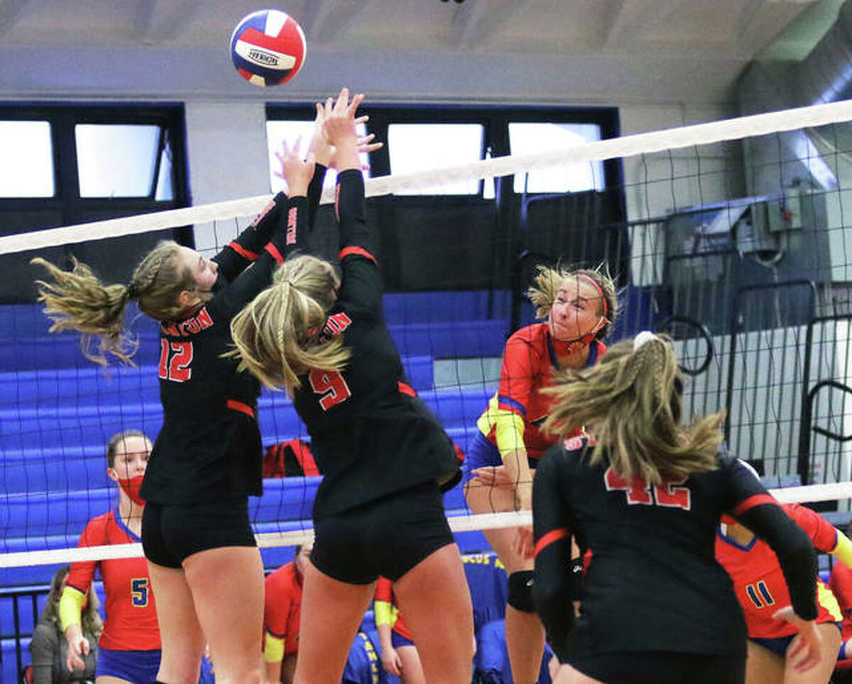 Roxana’s Macie Lucas (middle) hits over the block by Staunton’s Haris Legendre (12) and Danielle Russell (9) in a March 22 match in Roxana. On Saturday, Lucas and the Shells were in Wood River and beat their rival Oilers in two sets.