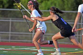 New Canaan's McKenna Hardenl , left, charges the net as Darien's Kate Bellissimo pursues during the FCIAC girls lacrosse championship in 2019 at Testa Field in Norwalk.