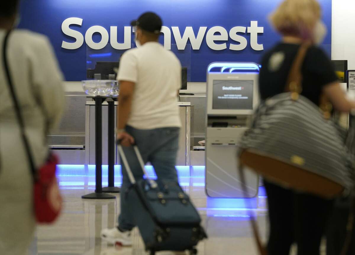 People in Terminal A at George Bush Intercontinental Airport pass by the Southwest Airlines counter Friday, April 9, 2021 in Houston. Southwest will have flights out of IAH for the first time on Monday.