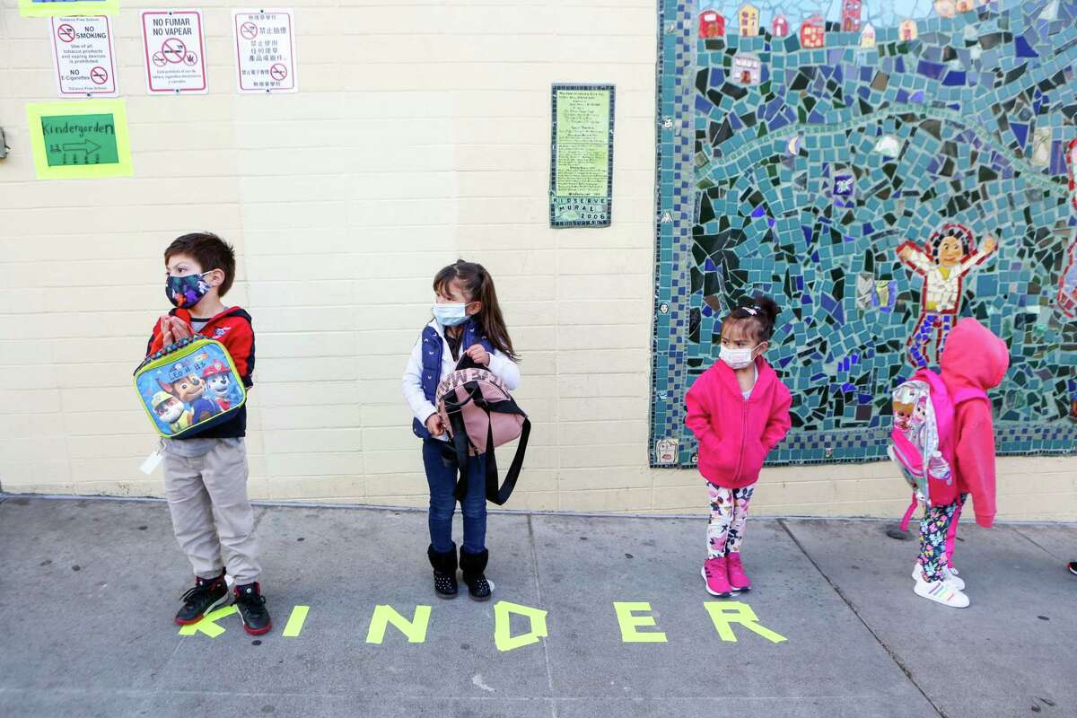 Pre-K students stand in line to check-in on the first day of in-person school in over a year at Bryant Elementary on April 12 in San Francisco. The district is looking for outside experts to help guide the process to fully reopen schools in August.
