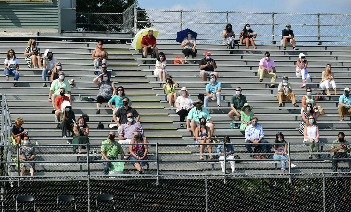 Graduates with the Norwalk High School Class of 2020 attend one of several small commencement ceremonies Tuesday, August 11, 2020, on the football field at the school in Norwalk, Conn.