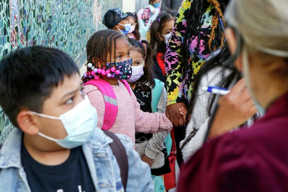 Children line up for the first day of in-person school in over a year at Bryant Elementary in San Francisco. Hospitals are seeing more kids with COVID-19, and the risk of so-called long COVID, marked by a variety of long-term symptoms, is not known.