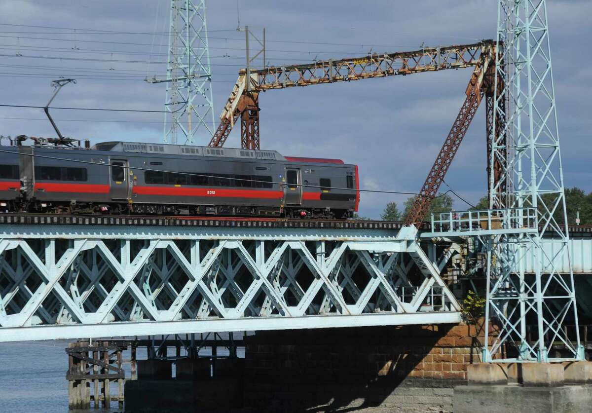 A northbound Metro-North train passes across the railroad bridge spanning Cos Cob Harbor in the Cos Cob section of Greenwich, Conn. Tuesday, Oct. 25, 2016. The state Department of Transportation said replacing the bridge is a priority project for federal funding from President Joe Biden’s proposed infrastructure bill.