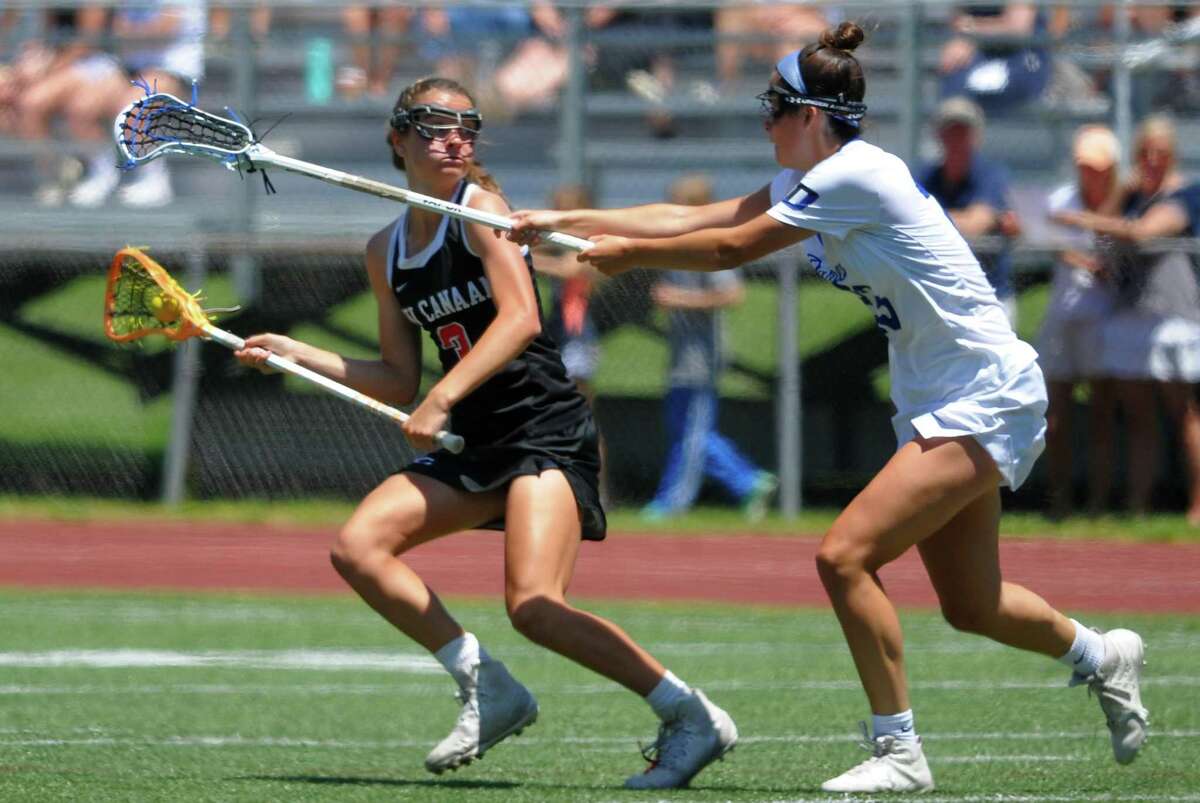 New Canaan's Dillyn Patten (3) maneuvers the ball as Darien's Maddie Joyce (23) blocks during girls Class L lacrosse action in Milford, Conn., on Saturday June 8, 2019.