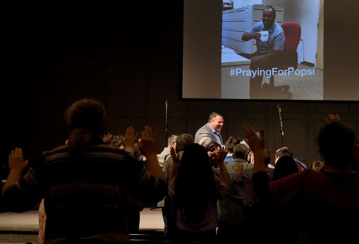 Worship leader Jeremy Fletcher gathers at the altar in praying overr an anoninted prayer cloth during a prayer vigil for Orange County Sheriff's officers Dru Crochet and Scott Barnes and Orange City. Policeman Howard DeVault at Eastgate United Pentecostal Church in Vidor Monday. The three officers are battling serious illesses, prompting the community to rally together in prayers and support. Photo made Monday, April 12, 2021 Kim Brent/The Enterprise