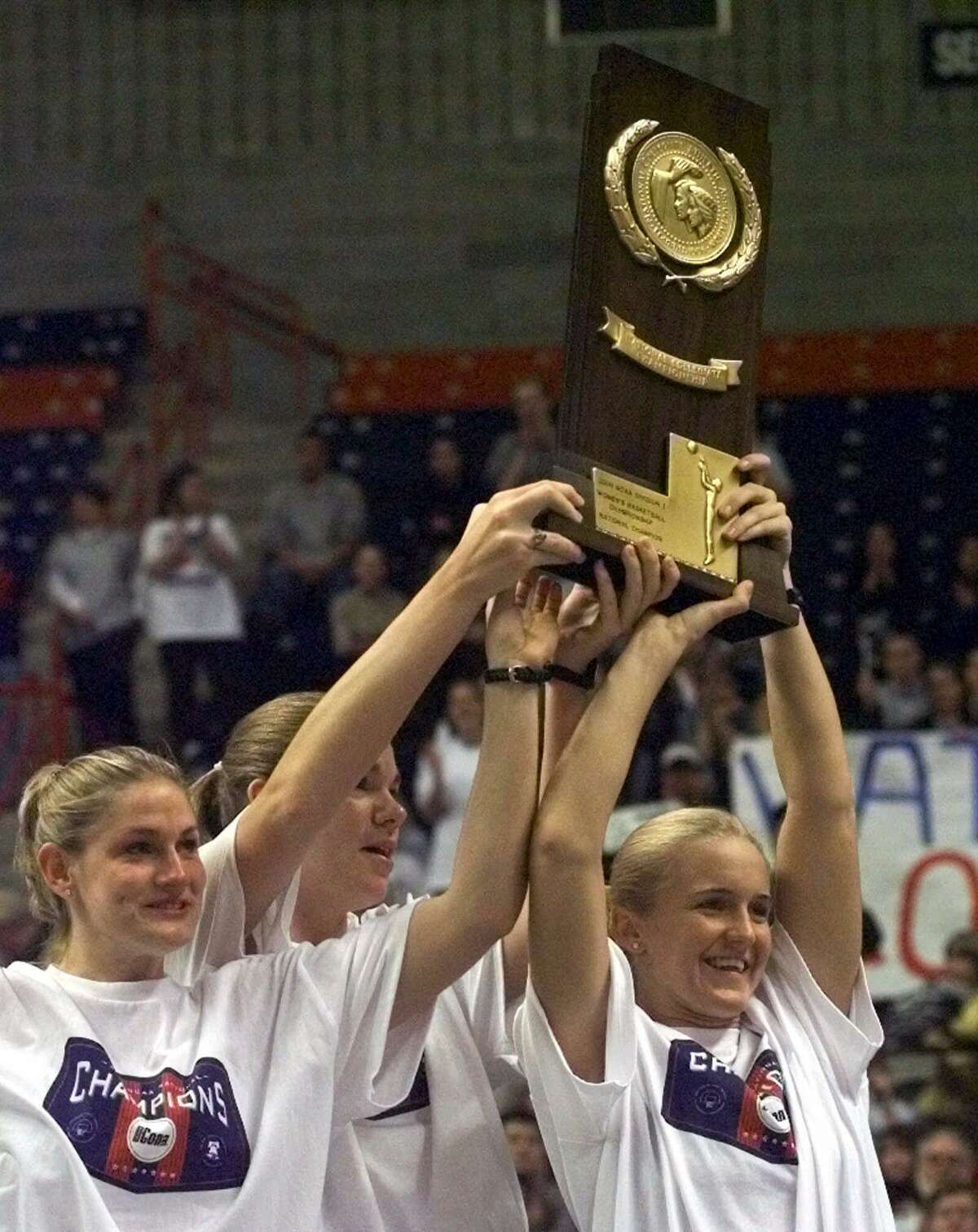 Connecticut women's basketball team captains Stacy Hansmeyer, left, Paige Sauer, center, and Shea Ralph, right, hold up the NCAA winners' trophy at a homecoming celebration on the campus of the University of Connecticut at Storrs, Conn., Monday, April 3, 2000. Connecticut won the 2000 NCAA Women's Basketball Championship Sunday, April 2, 2000, in Philadelphia by defeating Tennessee 71-52. (AP Photo/Bob Child)