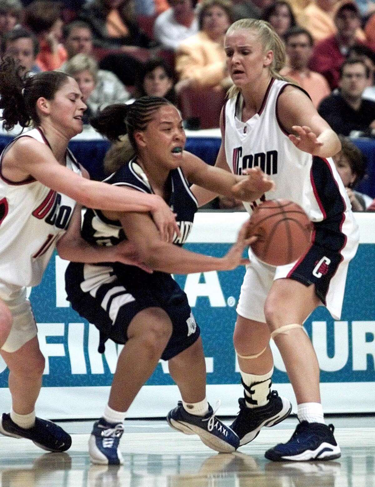 Penn State's Helen Darling, center, tries to pass as she is guarded by Connecticut's Sue Bird, left, and Shea Ralph, right, during the first half in the semi-finals of the Women's Final Four at the First Union Center in Philadelphia on Friday, March 31, 2000. (AP Photo/Rusty Kennedy)