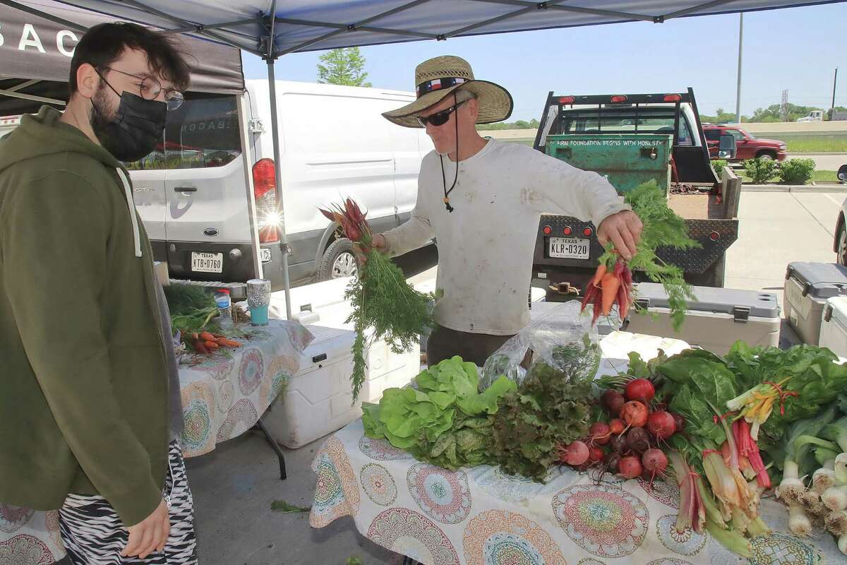 Joe Winter of Winter Family Farm helping a customer at the Bay Area Farmers Market. The farm lost much of its produce during the freeze.