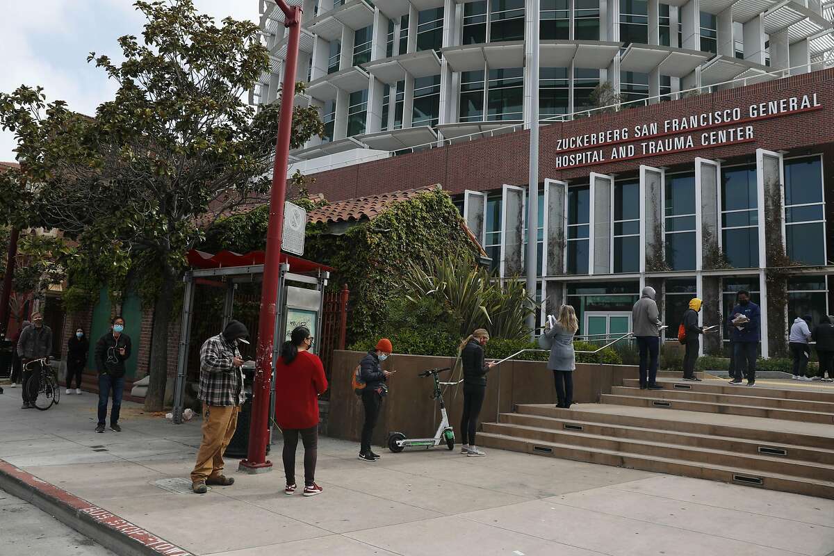 People line up along Potrero Avenue for COVID-19 vaccinations at San Francisco General Hospital.