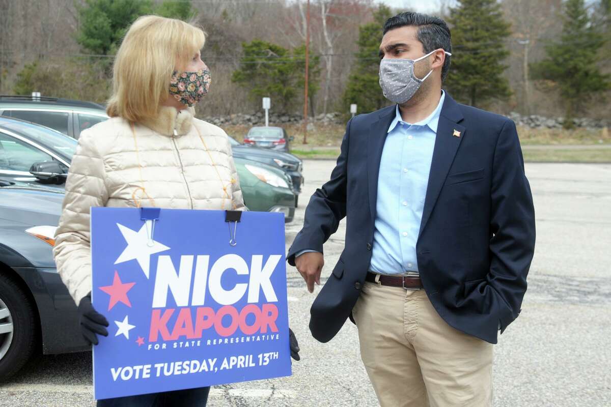 Democratic candidate Nick Kapoor speaks with supporter Karin Wynkoop while he greets voters during the special for the 112th House seat outside Fawn Hollow Elementary School, in Monroe, Conn. April 13, 2021.