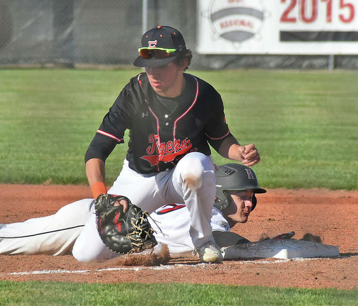 Edwardsville first baseman Riley Iffrig takes a pickoff throw while a Highland runner dives safely back to the bag during the first inning Tuesday at Glik Park in Highland.