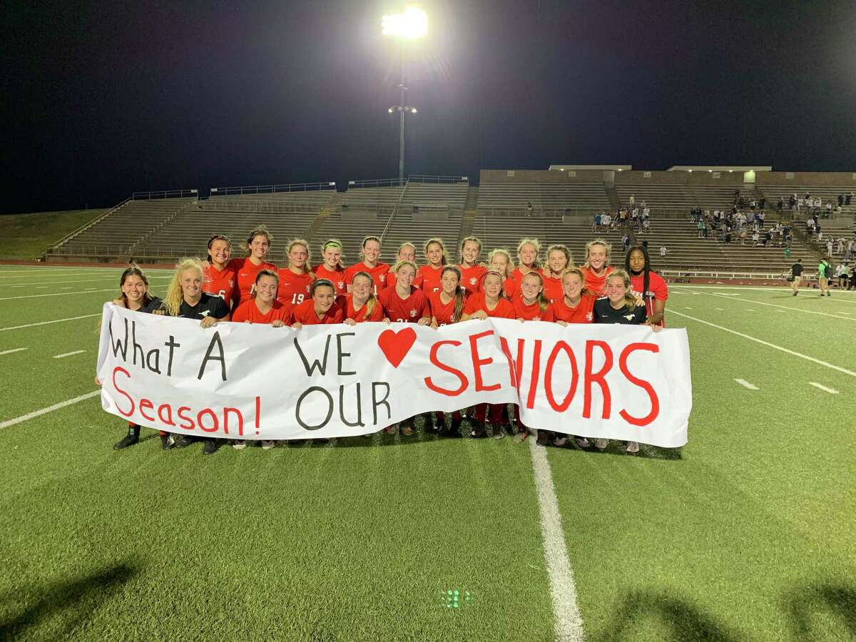 The Memorial girls soccer team poses by a banner celebrating its season and thanking its seniors after its season came to an end with a 3-0 loss to Vandegrift in the state semifinals on April 13 at Bryan ISD's Merrill Green Stadium